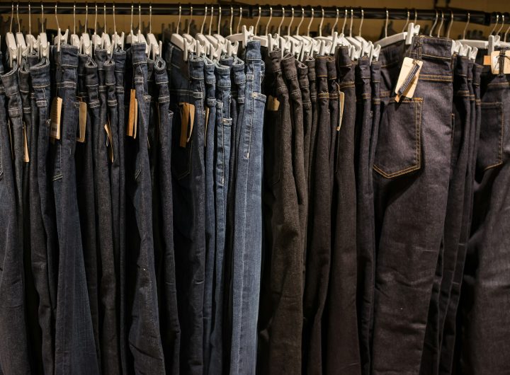 Jeans on clothes rail in clothing store at shopping mall.