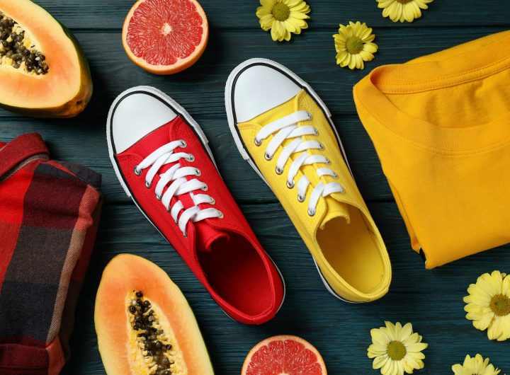 Summer clothes concept with sneakers on wooden background