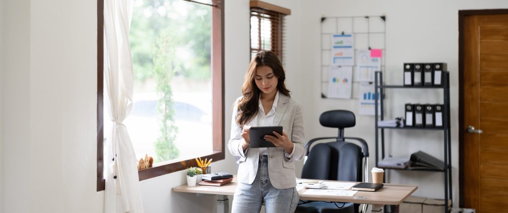 Woman accountant using calculator and digital tablet computer in office, finance and accounting