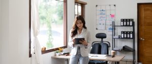 Woman accountant using calculator and digital tablet computer in office, finance and accounting