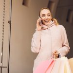 Young woman talking on phone after shopping in boutiques