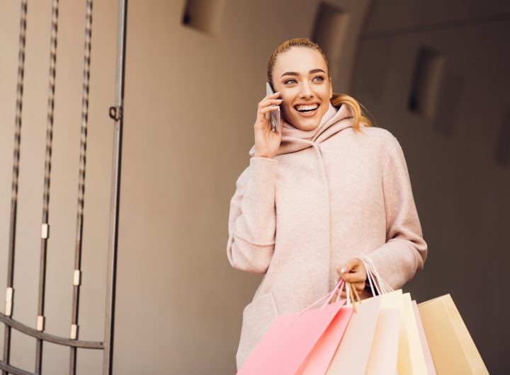 Young woman talking on phone after shopping in boutiques