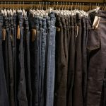 Jeans on clothes rail in clothing store at shopping mall.